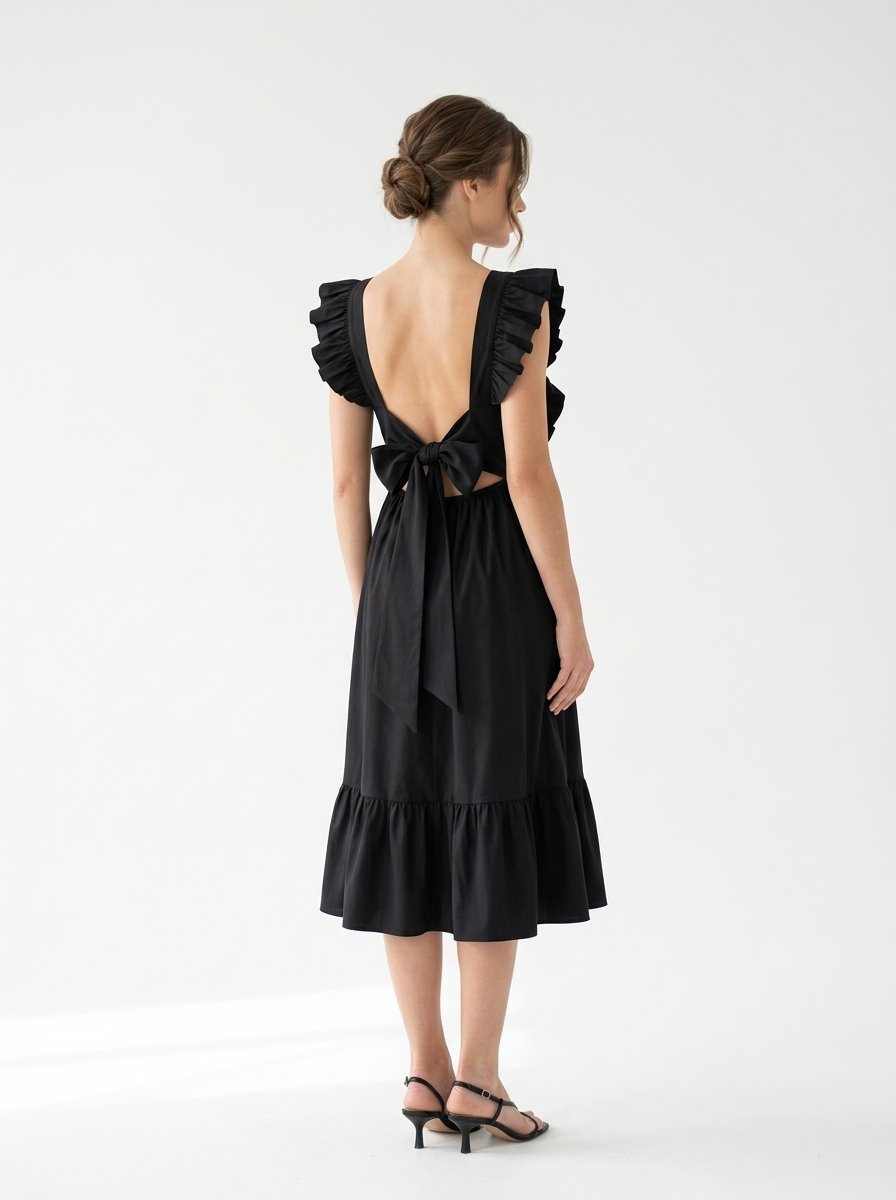 Mannequin portant la robe mi-longue noire 'Shadow' avec encolure carrée, bretelles à volants et jupe froncée, de la marque Divine Dress.