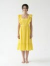 Mannequin portant la robe mi-longue jaune 'Shadow' avec encolure carrée, bretelles à volants et jupe froncée, de la marque Divine Dress.