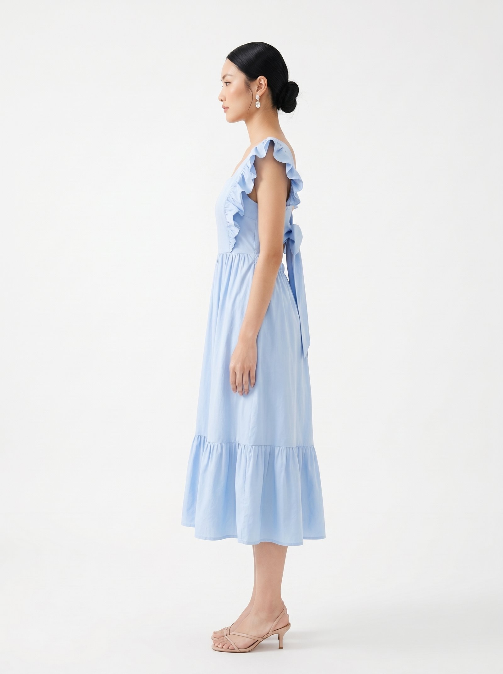 Mannequin portant la robe mi-longue bleu clair 'Shadow' avec encolure carrée, bretelles à volants et jupe froncée, de la marque Divine Dress.