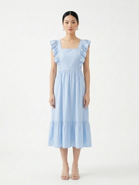 Mannequin portant la robe mi-longue bleu clair 'Shadow' avec encolure carrée, bretelles à volants et jupe froncée, de la marque Divine Dress.