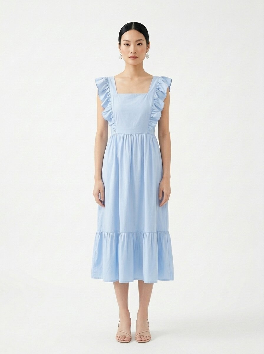 Mannequin portant la robe mi-longue bleu clair 'Shadow' avec encolure carrée, bretelles à volants et jupe froncée, de la marque Divine Dress.