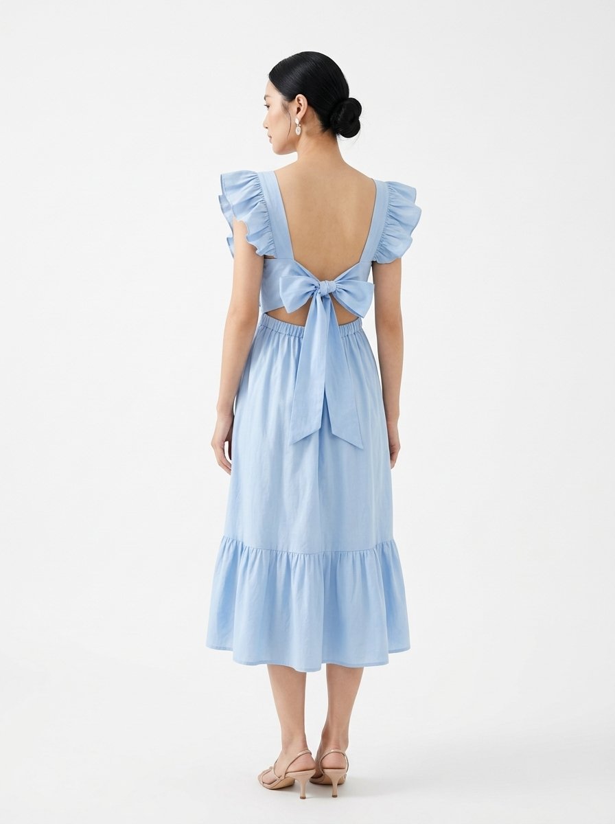 Mannequin portant la robe mi-longue bleu clair 'Shadow' avec encolure carrée, bretelles à volants et jupe froncée, de la marque Divine Dress.