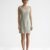 Mannequin portant la robe courte minimaliste vert sauge 'Muted Sage' avec col rond et coupe sans manches, de la marque Divine Dress.