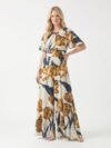 Mannequin portant la combinaison pantalon fluide crème à grand imprimé floral tulipes 'Flourish', avec manches évasées et taille marquée, de la marque Divine Dress.