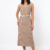 Mannequin portant la robe midi beige à rayures blanches 'Desert Breeze' avec encolure carrée, bretelles et ceinture en corde, de la marque Divine Dress.