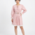 Adoptez un style doux et féminin avec la robe rose 'Azure' de Divine Dress. Finitions blanches délicates, col à nouer et taille ceinturée. Commandez-la.