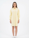 Mannequin souriante portant la robe chemise courte jaune pâle 'Aura' avec manches longues froncées et coupe ample, de la marque Divine Dress.