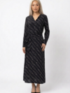 Mannequin portant la robe longue noir à motif géométrique 'Geometric Grace', avec col en V, manches longues et ceinture à nouer, de la marque Divine Dress.