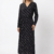 Mannequin portant la robe longue noir à motif géométrique 'Geometric Grace', avec col en V, manches longues et ceinture à nouer, de la marque Divine Dress.