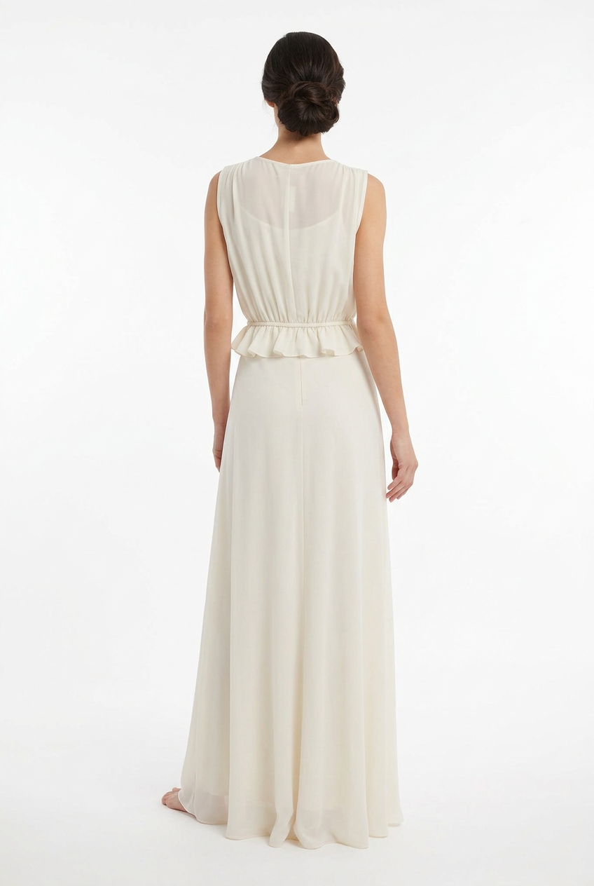 Mannequin portant la robe longue fluide blanc cassé 'Athena' avec décolleté en V, taille froncée à cordon et détails volantés, de la marque Divine Dress.