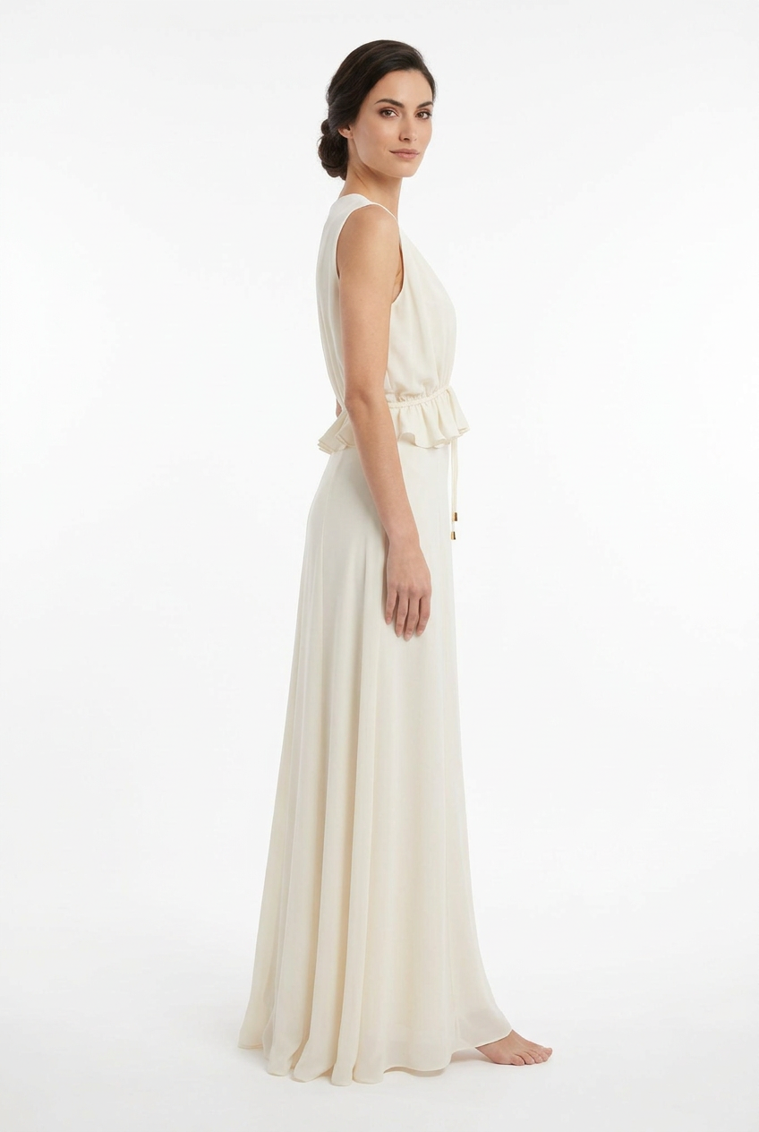 Mannequin portant la robe longue fluide blanc cassé 'Athena' avec décolleté en V, taille froncée à cordon et détails volantés, de la marque Divine Dress.