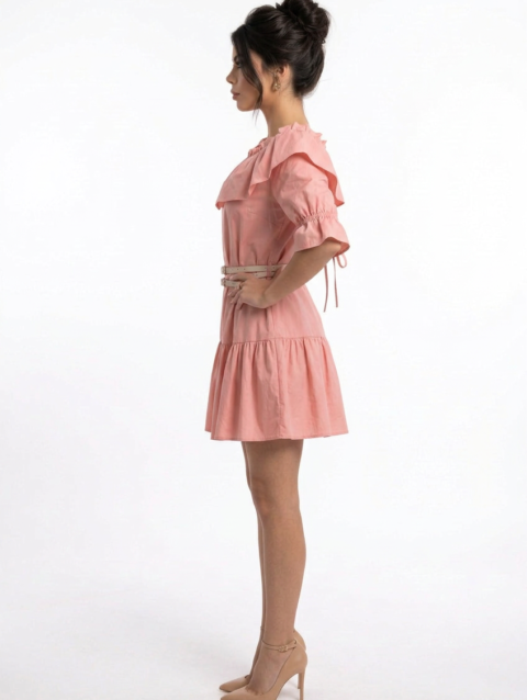 Mannequin portant la robe courte rose 'Pink Petal' avec col à volants, manches froncées à nouer et double fine ceinture, de la marque Divine Dress.
