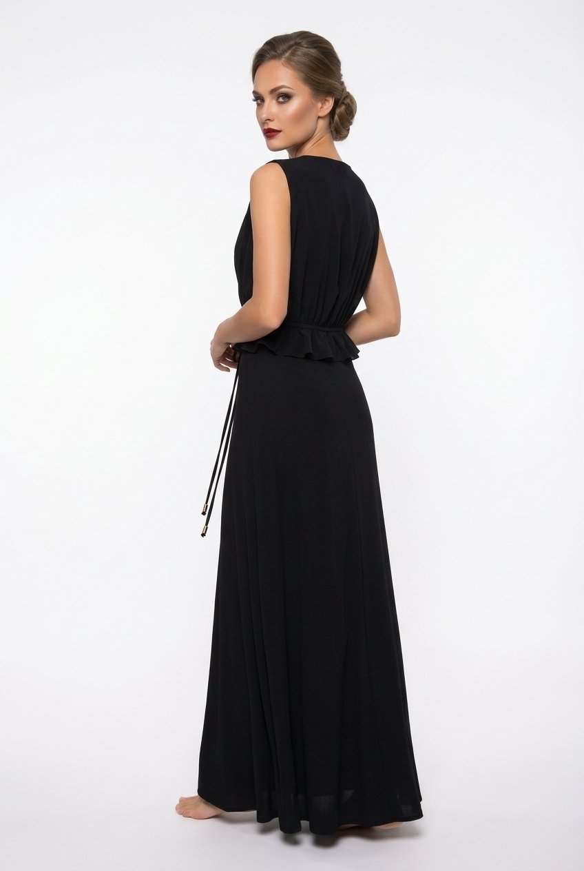 Mannequin portant la robe longue fluide noir 'Athena' avec décolleté en V, taille froncée à cordon et détails volantés, de la marque Divine Dress.