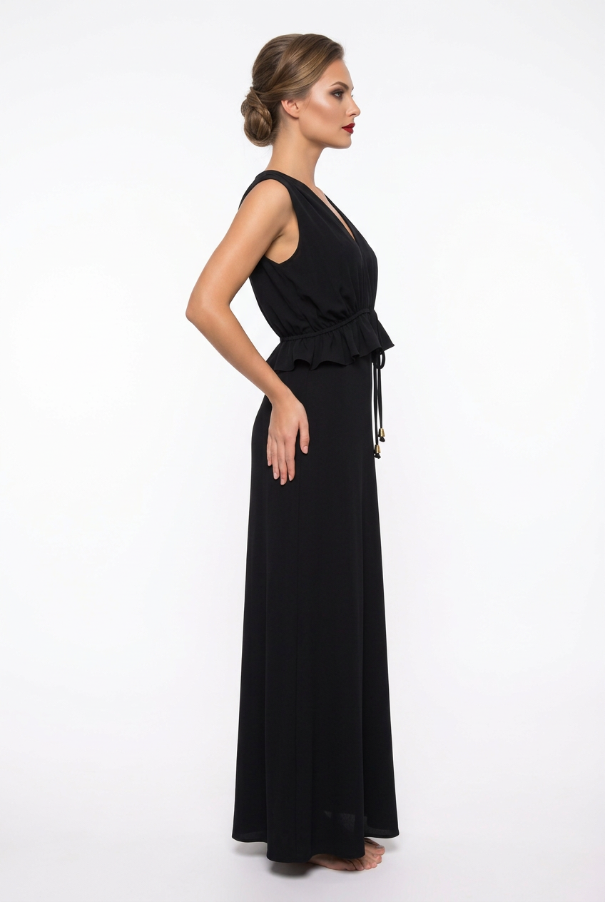 Mannequin portant la robe longue fluide noir 'Athena' avec décolleté en V, taille froncée à cordon et détails volantés, de la marque Divine Dress.