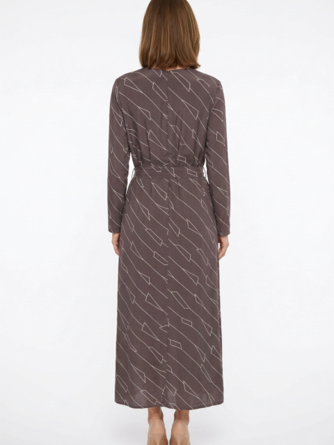 Mannequin portant la robe longue marron à motif géométrique 'Geometric Grace', avec col en V, manches longues et ceinture à nouer, de la marque Divine Dress.