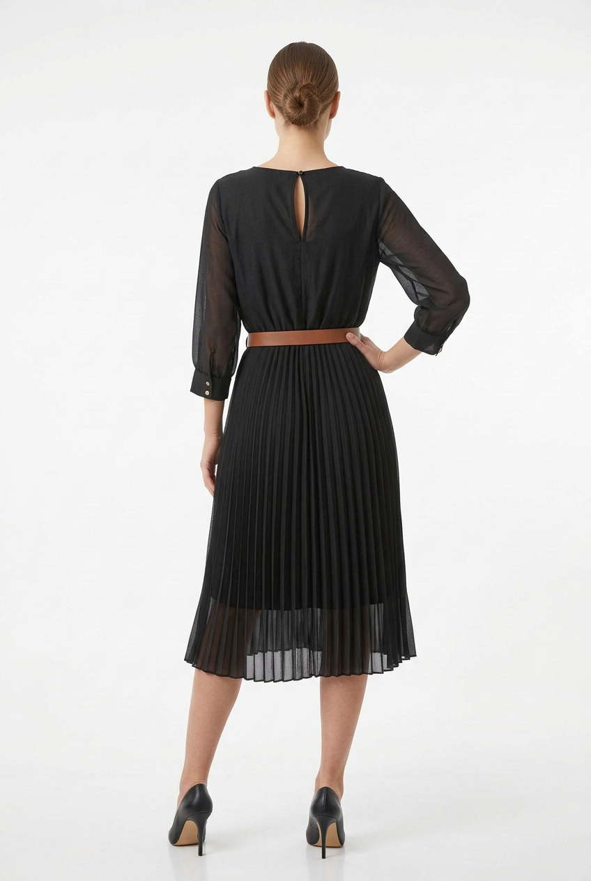 Mannequin portant la robe midi noir 'Velvet Touch' avec jupe plissée, manches 3/4 et large ceinture décorative, signée Divine Dress.