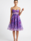 Mannequin portant la robe courte violette à imprimé floral 'Blossom' avec corsage bustier et jupe évasée, de la marque Divine Dress.