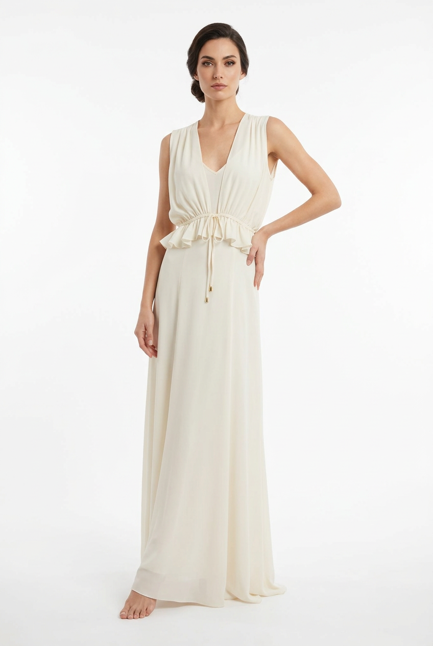 Mannequin portant la robe longue fluide blanc cassé 'Athena' avec décolleté en V, taille froncée à cordon et détails volantés, de la marque Divine Dress.