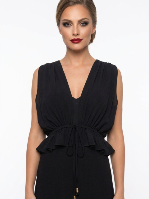 Mannequin portant la robe longue fluide noir 'Athena' avec décolleté en V, taille froncée à cordon et détails volantés, de la marque Divine Dress.
