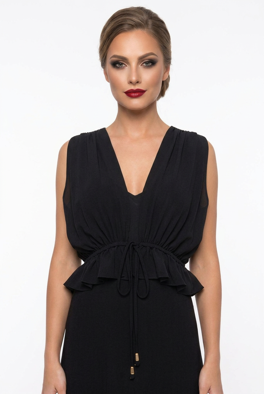 Mannequin portant la robe longue fluide noir 'Athena' avec décolleté en V, taille froncée à cordon et détails volantés, de la marque Divine Dress.